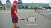 The player stands on the court, holding the racket with the right hand, palm facing down, strings facing right and left, and head pointing towards the net.