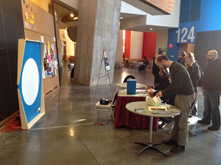 A photo of several people playing a version of Spacewar that was made by the MIT-Singapore GAMBIT Lab in honor of Spacewar's 50th anniversary.