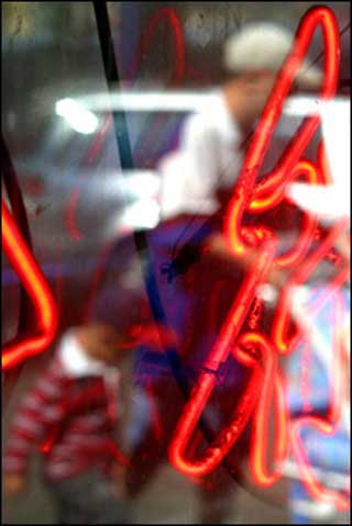 Figures reflected in a Chinatown shop window, in Boston, MA.