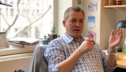 Man sitting in office chair gesticulating.