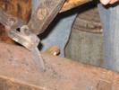 Gripping the opener with tongs, the corners are rounded and the surfaces hammered smooth.