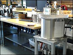 Small experiment equipment on the table and a big cylinder shape equipment on the floor.