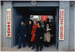 A photo of Mrs. Nixon walking through a large doorway with a crowd of people.