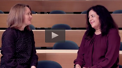 Two women sitting, facing each other, and talking.