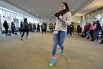 A high school aged girl walking in the middle of a circle of girls.