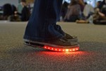 Sneakers with a strip of red lit up LEDs.