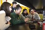 A photo of a group of girls working with a volunteer to build their cameras.