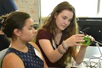 A photo of two girls working on building a camera.